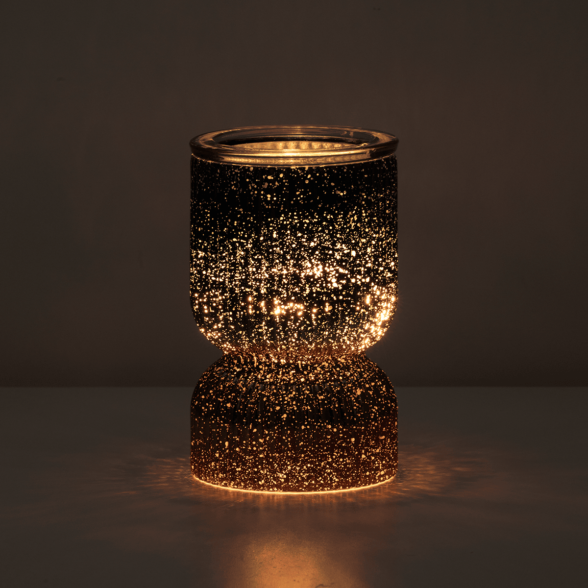 Decorative candle holder with a sparkling, glowing effect on a dark background