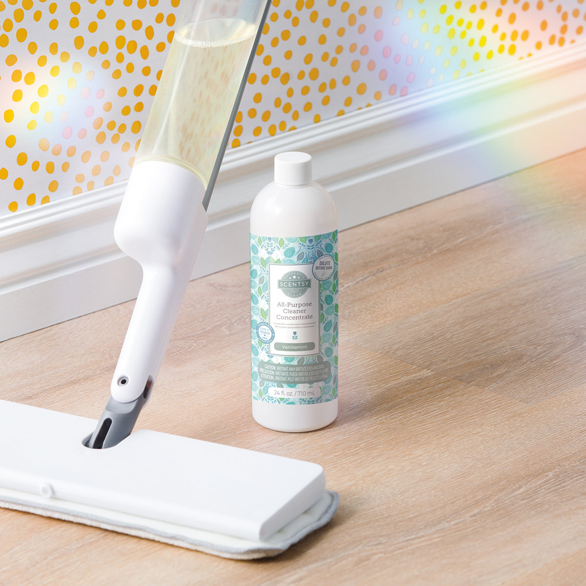 Mop and bottle of cleaning solution on a wooden floor with a polka dot wall in the background