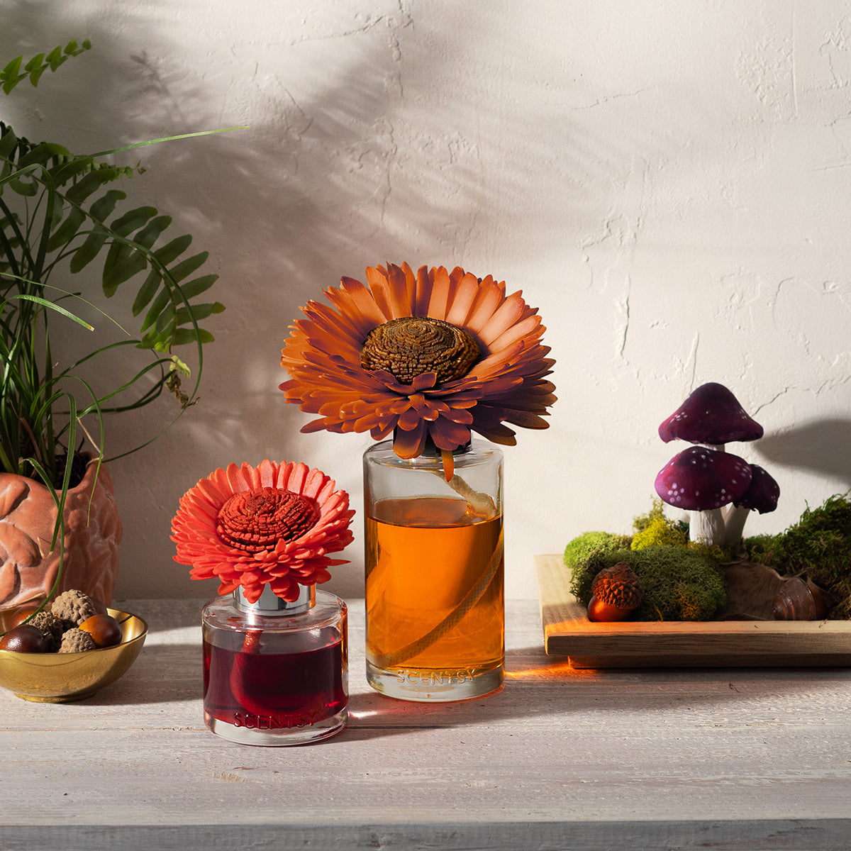 Two small glass containers with floral designs on a wooden surface, surrounded by decorative elements.