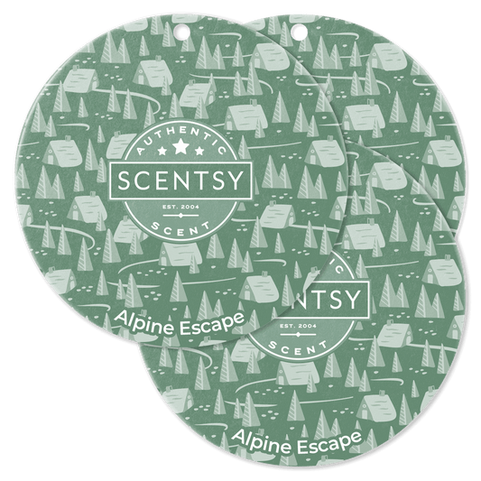 Two Scentsy Alpine Escape scented wax melts with a forest pattern on a black background.