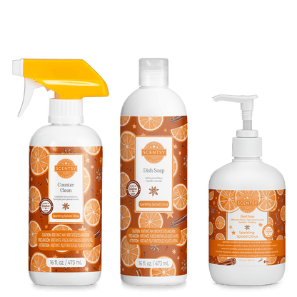 Set of Scentsy products including a spray bottle, dish soap, and hand soap with orange and cinnamon design on a green background.