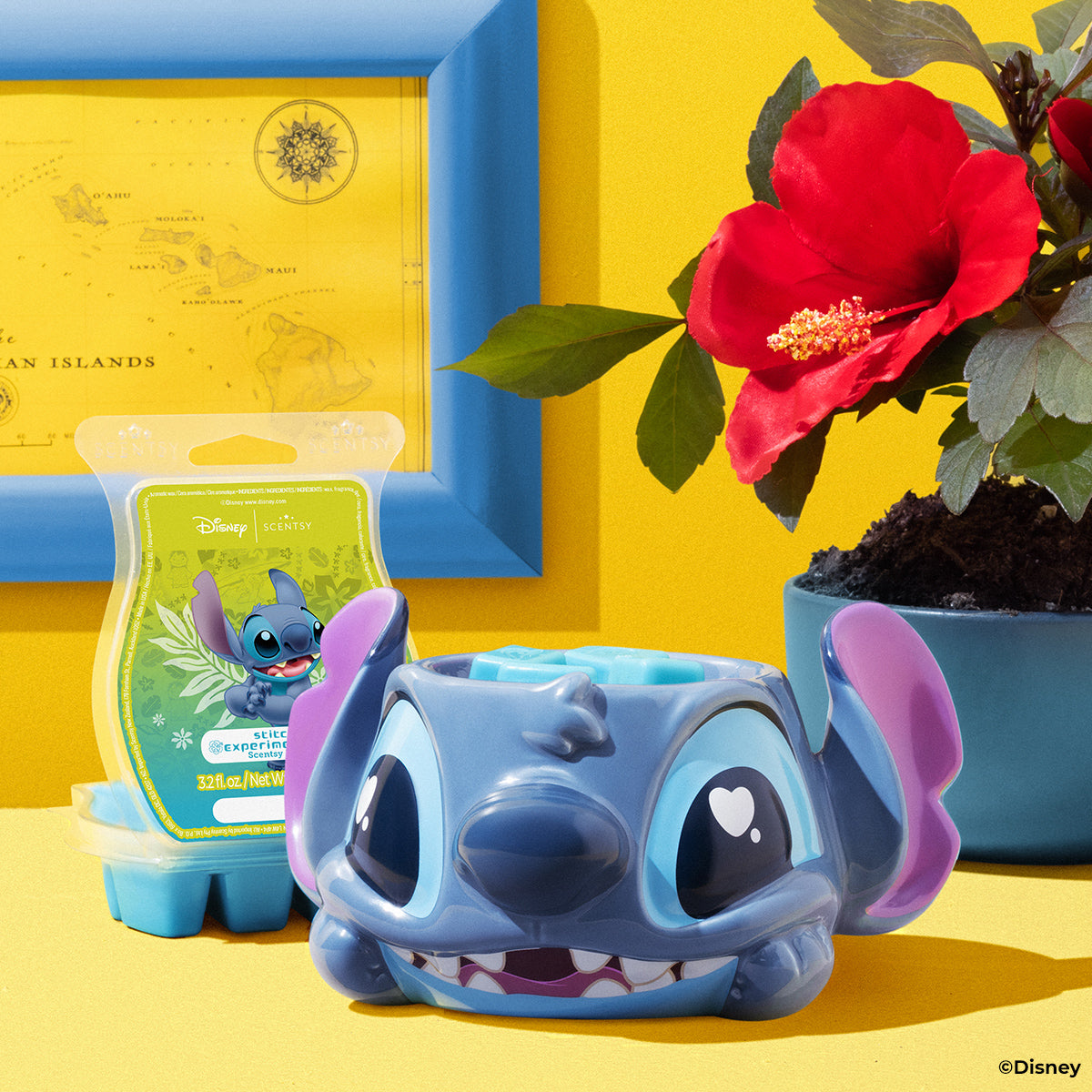 Blue cartoon character figurine with a yellow box and red flower in the background