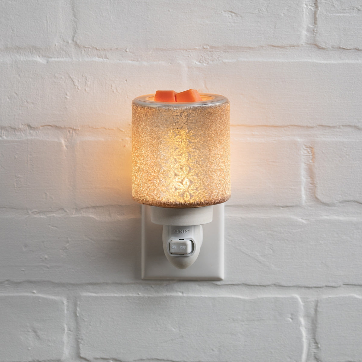 Decorative night light with floral pattern on a white brick wall