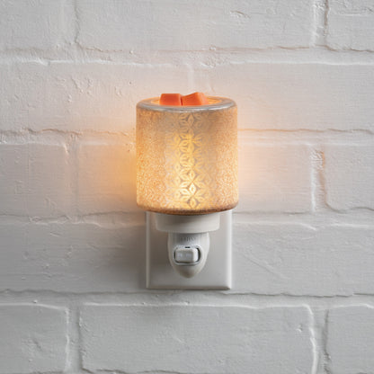 Decorative night light with floral pattern on a white brick wall