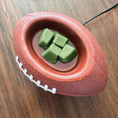 Red football-shaped pet toy with green treats on a wooden surface