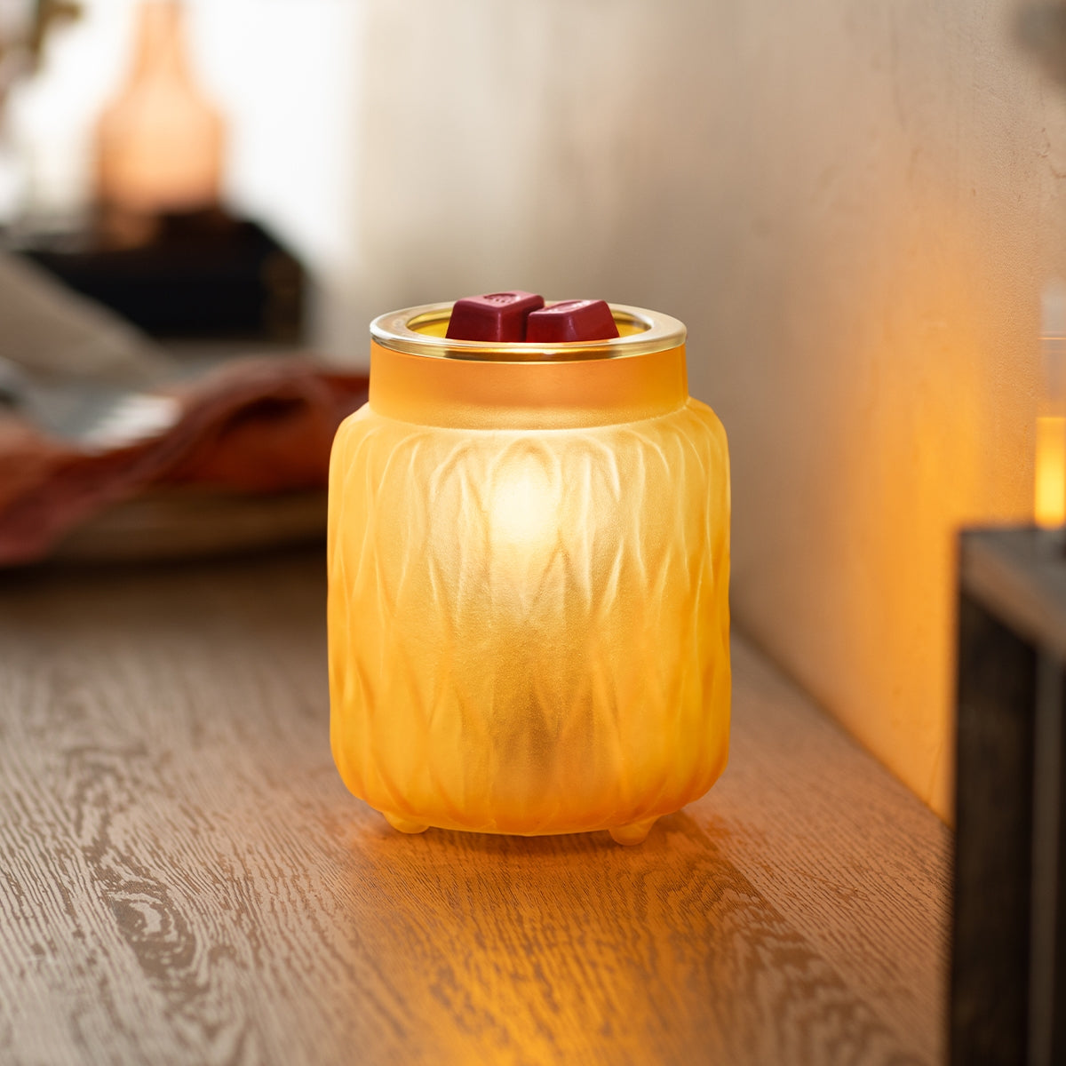 Wax warmer with wax melts on a wooden surface