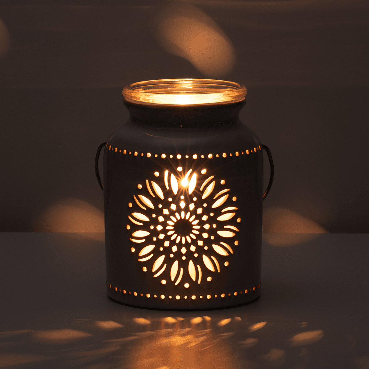 Decorative lantern with intricate cut-out design on a dark background