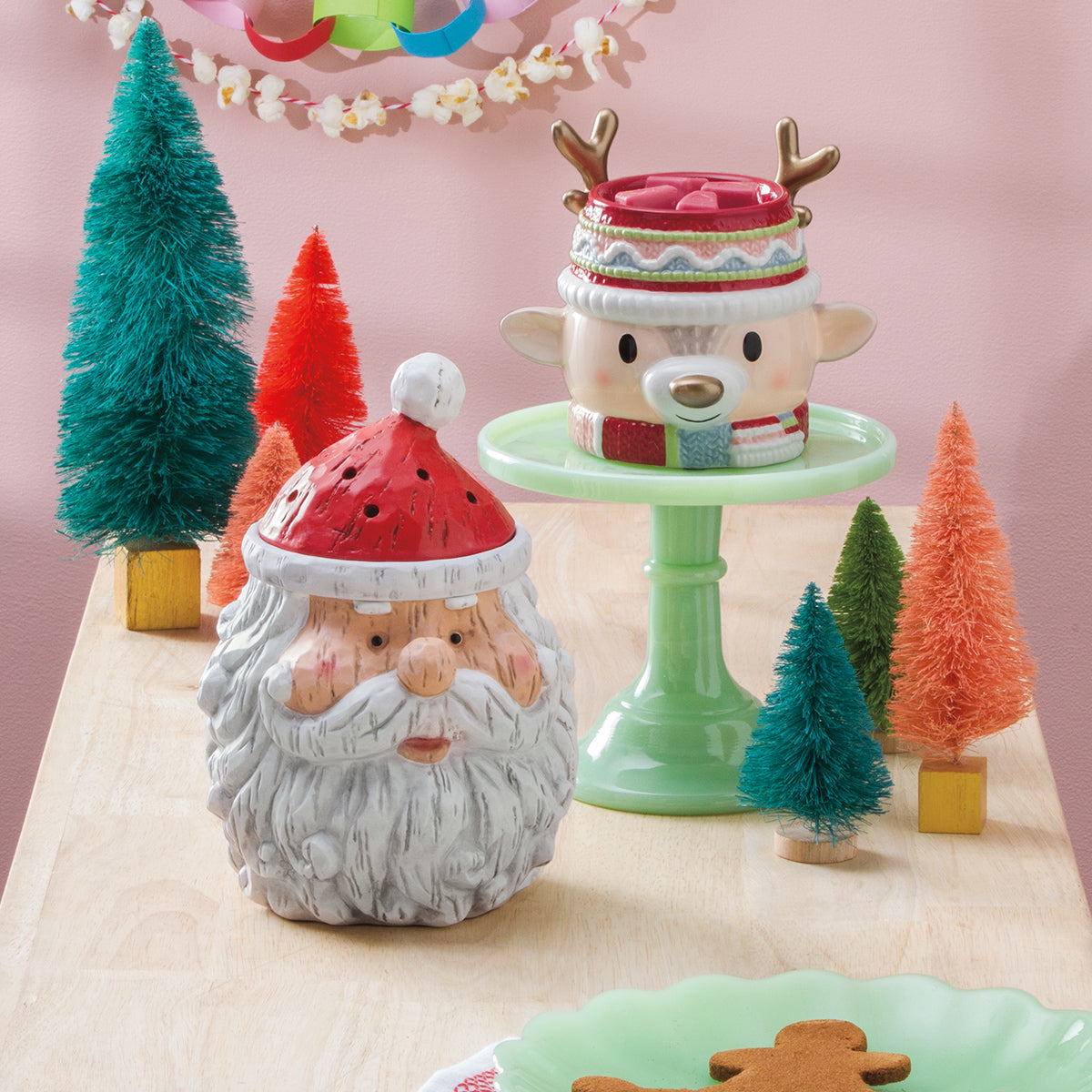 Decorative Christmas items including a Santa Claus figure and reindeer with a cake stand on a table.