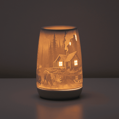 Decorative lamp with engraved scene of a cabin and nature on a dark background