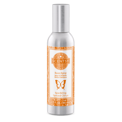 Scentsy room spray bottle with orange label on a green background