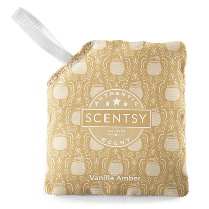 Scentsy Vanilla Amber warmer with a white handle on a green background