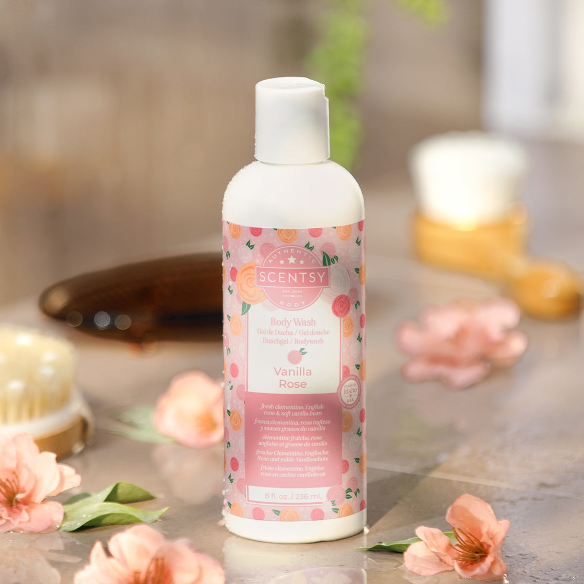 Scentsy Vanilla Rose body wash bottle on a bathroom counter with flowers and soap.
