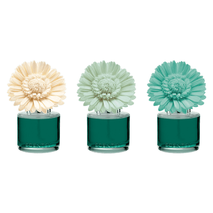 Three floral perfume bottles with different colored flowers on a black background