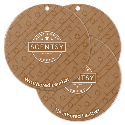 Two Scentsy Weathered Leather scented wax discs on a black background