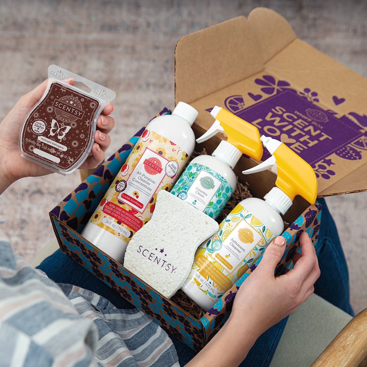 Scentsy products including candles and diffusers in a box with 'Scent with Love' branding.