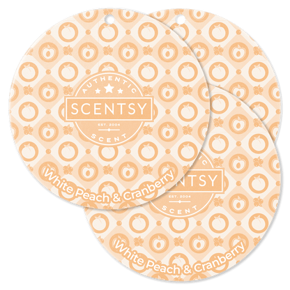 Two Scentsy White Peach & Cranberry scented wax discs on a black background