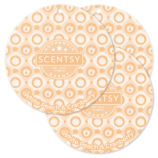 Two Scentsy White Peach & Cranberry scented wax discs on a black background