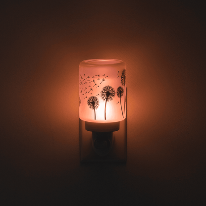 Decorative night light with dandelion design on a dark background